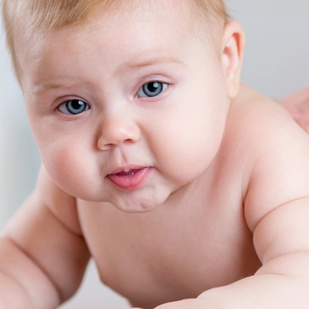Close-Up Portrait Of An Infant Looking Toward The Camera