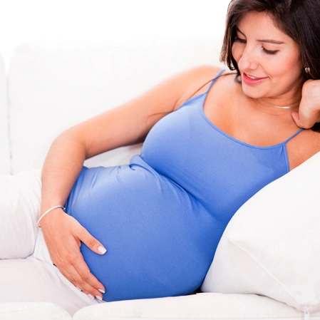 Pregnant Individual Resting On A Bed
